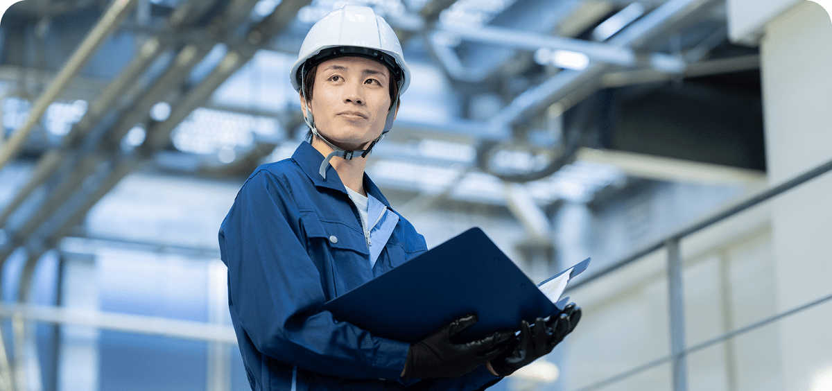 Industrial worker in blue uniform holding documents