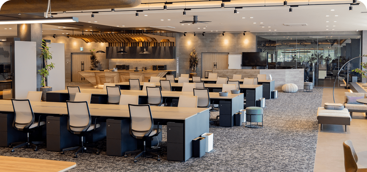 Modern open-plan office with desks and chairs.